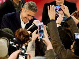 George Clooney, actor de la película 'The Monuments Men', firma autógrafos a su llegada al Festival. AP /