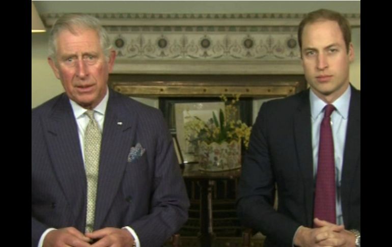 Padre e hijo, vestidos con traje y sentados uno junto al otro en el palacio de Clarence House. EFE /