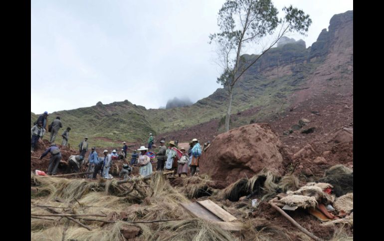 Habitantes de la aldea buscan entre el lodo a posibles sobrevivientes. AP /