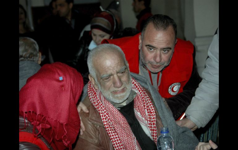 Un civil sirio es ayudado por miembros de la Media Luna Roja a su llegada a un centro de evacuación. EFE /