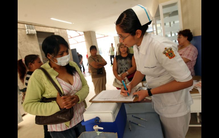 Una enfermera habla con una enferma de influenza. ARCHIVO /