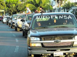 Camionetas de las defensas rurales arriban al municipio de Apatzingán, el bastión de los Caballeros Templarios. AP /