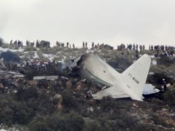 Personas se reúnen en el sitio donde se estrelló la aeronave. AP /