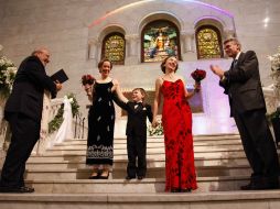 Una pareja de mujeres sostiene de la mano a un niño, quien las acompañó en su boda. ARCHIVO /