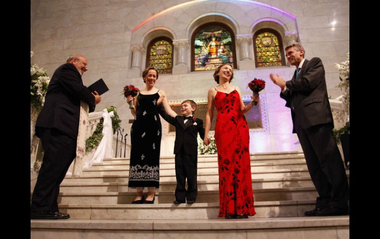 Una pareja de mujeres sostiene de la mano a un niño, quien las acompañó en su boda. ARCHIVO /