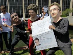 Artistas disfrazados representan una escena cómica en la que Rousseff da a Snowden un pasaporte brasileño y Obama trata de evitarlo. AP /