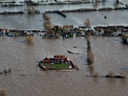 Las inundaciones obligan a miles de personas a abandonar sus casas y provocaron problemas en los servicios de transporte. AP /