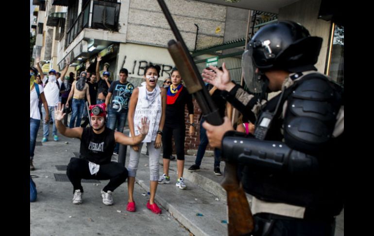 Estudiantes y miembros de la policía bolivariana se enfrentan en Caracas. EFE /