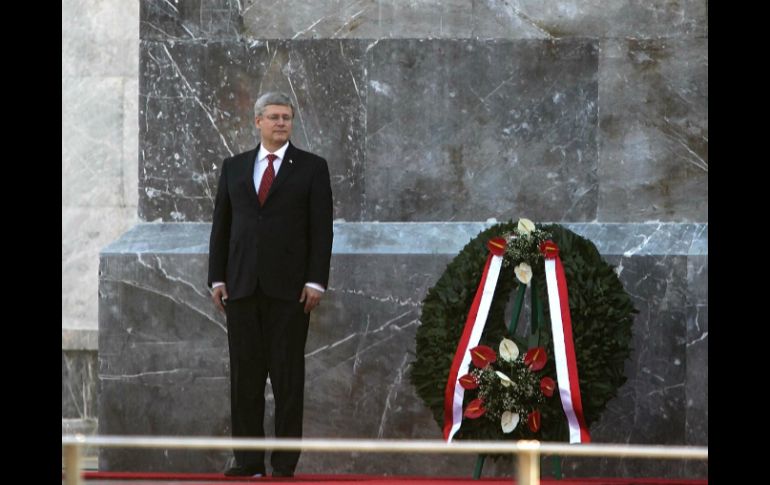 El primer ministro canadiense coloca un arreglo floral, como lo han hecho otros mandatarios. SUN /