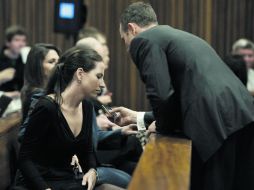 Oscar Pistorius le muestra un mensaje en su teléfono a su hermana Aimee Pistorius, en un pausa del juicio por asesinato que se le sigue AFP /