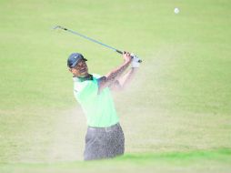 Tiger Woods ejecuta su tiro desde la trampa de arena en el hoyo 16. AFP /