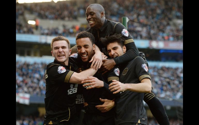 James Perch (centro) es felicitado tras darle al Wigan el segundo gol ante Manchester City, durante el partido de cuartos de final. EFE /