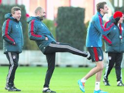 Buen ánimo. Pep Guardiola patea a Thomas Müller durante el entrenamiento del lunes del Bayern Munich. AP /