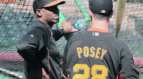 Consejos del que sabe. Barry Bonds platica con el receptor Buster Posey durante la práctica de bateo de San Francisco. AFP /