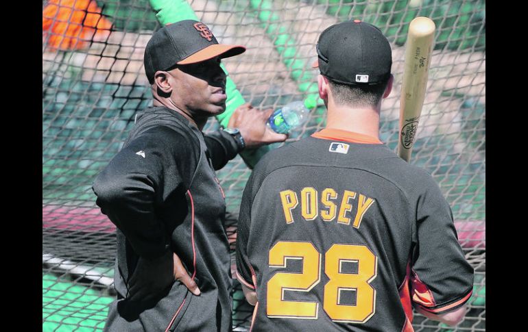 Consejos del que sabe. Barry Bonds platica con el receptor Buster Posey durante la práctica de bateo de San Francisco. AFP /