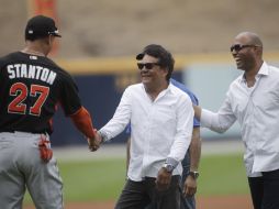 El campeón parameño le estrecha la mano al beisbolista Giancarlo Stanton luego de hacer el lanzamiento de honor. AP /