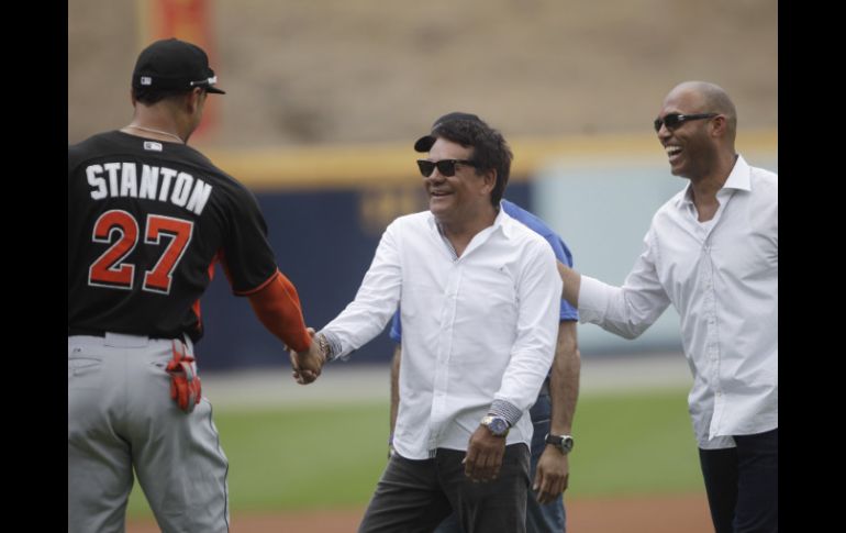 El campeón parameño le estrecha la mano al beisbolista Giancarlo Stanton luego de hacer el lanzamiento de honor. AP /