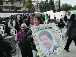 In memoriam. Dos señoras acuden a  la Plaza de la Unidad, en Magdalena de Kino, con un retrato del ex candidato del tricolor. NTX /