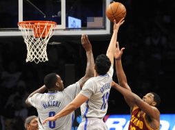 Gutiérrez (13) y Blatche (0), de Nets de Brooklyn, bloquean el encesto de Thompson (13), de Cavaliers de Cleveland, en el partido. AP /