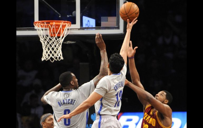 Gutiérrez (13) y Blatche (0), de Nets de Brooklyn, bloquean el encesto de Thompson (13), de Cavaliers de Cleveland, en el partido. AP /