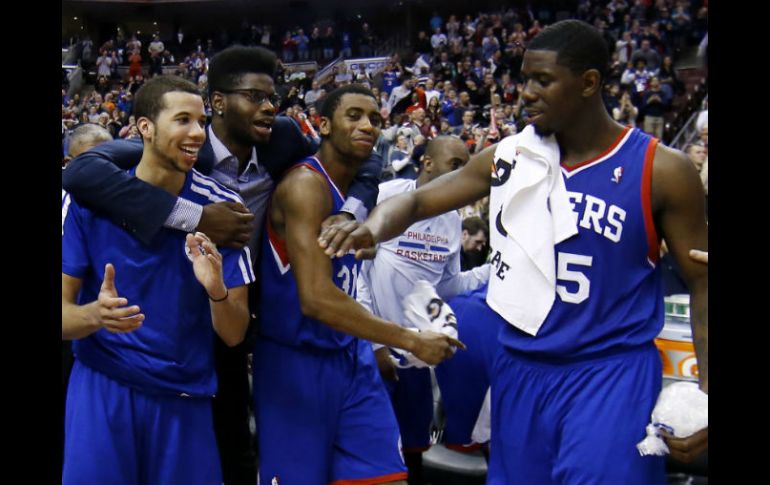 Michael Carter-Williams, Nerlens Noel, Hollis Thompson y Henry Sims celebran al término del juego. AP /