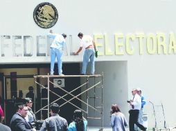 Obreros cambiaron ayer el rótulo exterior del edificio del IFE fundado hace dos décadas para adaptarlo a su nuevo nombre. NTX /