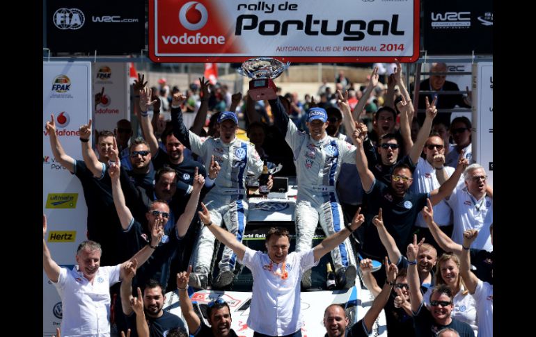 El piloto Sébastien Ogier y el copiloto Julien Ingrassia celebran su triunfo en el Mundial de Rally, junto con el equipo de Volkswagen AFP /