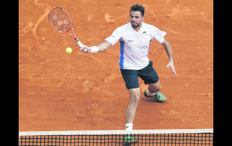 A tiempo. Stanislas Wawrinka sube a la red para rematar una pelota. El tenista suizo ganó la final por parciales de 4-6, 7-6 (5), 6-2. AP /