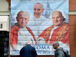 Un póster muestra al Papa Francisco y a los próximos santos, Juan Pablo II y Juan XXIII; el Vaticano prepara sus canonizaciones. AFP /