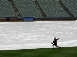 La cancha del estadio fue cubierta con una lona por la lluvia. AP /