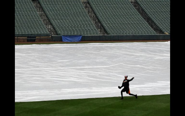 La cancha del estadio fue cubierta con una lona por la lluvia. AP /