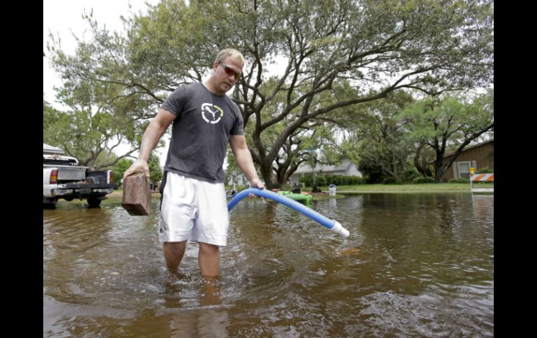 Un ciudadano camina entre las calles inundadas en Florida. AP /