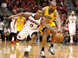 David West (21) pelea el balón con Jeff Teague. El de Indiana hizo 24 puntos en el juego. AFP /