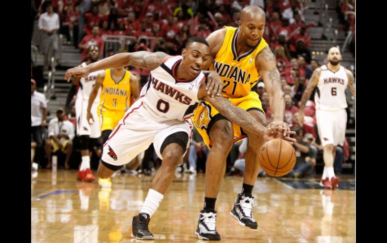 David West (21) pelea el balón con Jeff Teague. El de Indiana hizo 24 puntos en el juego. AFP /