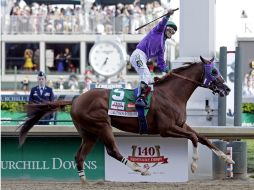 Víctor Espinoza levanta el brazo al cruzar la meta y llevarse la edición 140 del Derby de Kentucky. AP /