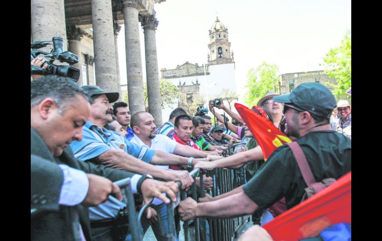 En la manifestación de ayer, Día del Maestro, docentes de la CNTE tratar de tirar una valla que limitaba el acceso al Teatro Degollado.  /