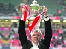 Ya llovió. Arsene Wenger levanta la FA Cup que en 2005 ganaron al Manchester United en penales.  /