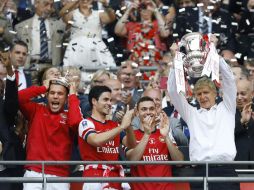 Arsene Wenger, técnico del Arsenal, sostiene la Copa de Inglaterra y celebra con su equipo la victoria del campeonato. AP /