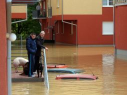 Ciudadanos de Serbia esperan su evacuación frente a inundaciones que alcanzan a cubrir los automóviles. AFP /