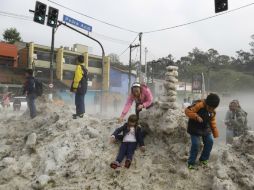 Niños juegan en una pila de hielo en las calles de Sao Paulo. AP /