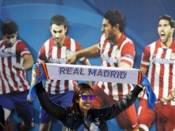 Previo al juego de la final del próximo sábado una aficionada del Real Madrid levanta su bufanda del Real Madrid. AP /