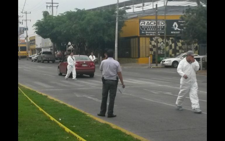 Agentes de la Fiscalía General del Estado y del Instituto Jalisciense de Ciencias Forenses realizan el levantamiento del cadáver.  /