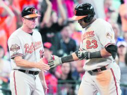 Nelson Cruz es felicitado por el coach de tercera de Baltimore, Bobby Dickerson, luego de conectar su jonrón en la octava entrada. AFP /