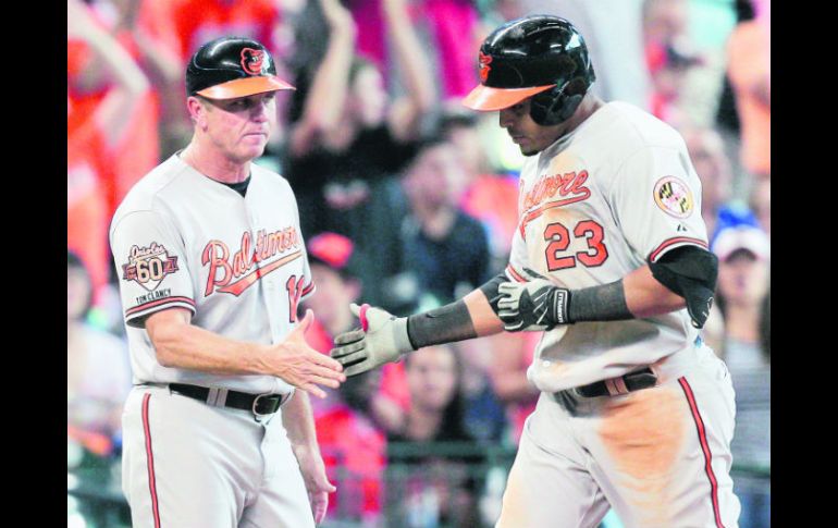 Nelson Cruz es felicitado por el coach de tercera de Baltimore, Bobby Dickerson, luego de conectar su jonrón en la octava entrada. AFP /