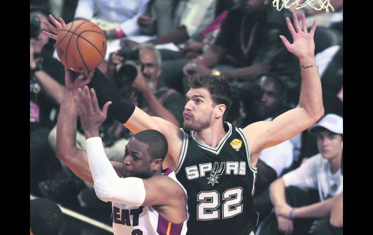 Tigo Splitter obstaculiza el tiro de Dwyane Wade anoche, en el tercer juego de la serie por el campeonato de la NBA. AFP /