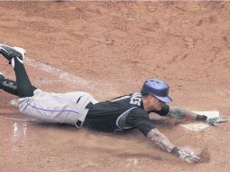 Brandon Barnes llega barrido al home plate luego de batear su jonrón dentro del parque y anotar la carrera de la victoria para Colorado AP /