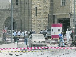 Agentes forenses y peritos de Inteligencia libanesa revisan el sitio del ataque con el coche-bomba. AFP /