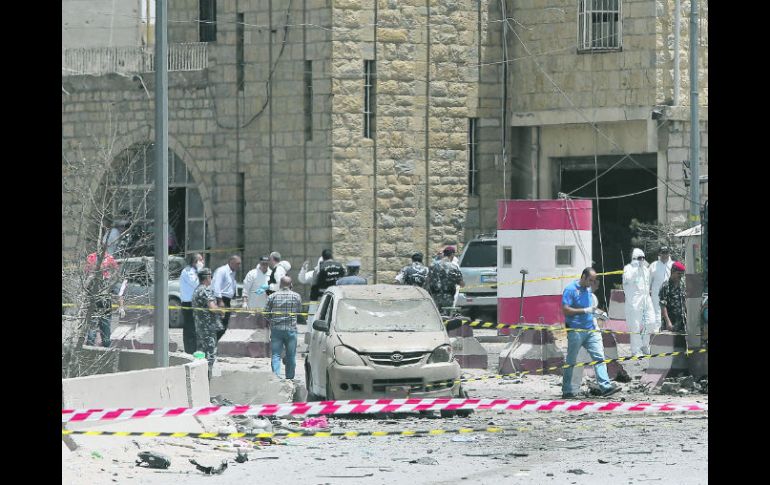 Agentes forenses y peritos de Inteligencia libanesa revisan el sitio del ataque con el coche-bomba. AFP /