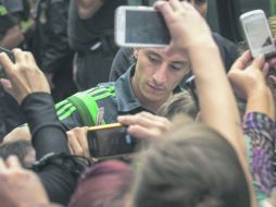 El defensa Andrés Guardado firma autógrafos entre decenas de aficionados en Santos (Brasil). EFE /