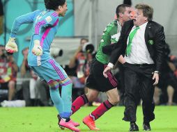 FESTEJO. El “Piojo” al momento de celebrar el segundo gol de México a Croacia. Guillermo Ochoa saltó encima de su DT. AFP /